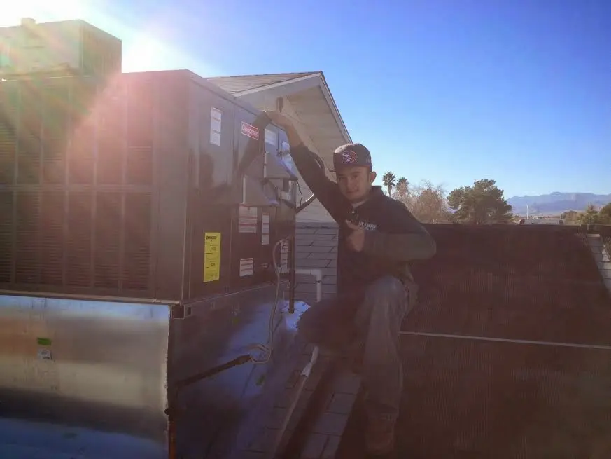 HVAC technician performing AC Tune-Up on a rooftop unit in Springfield